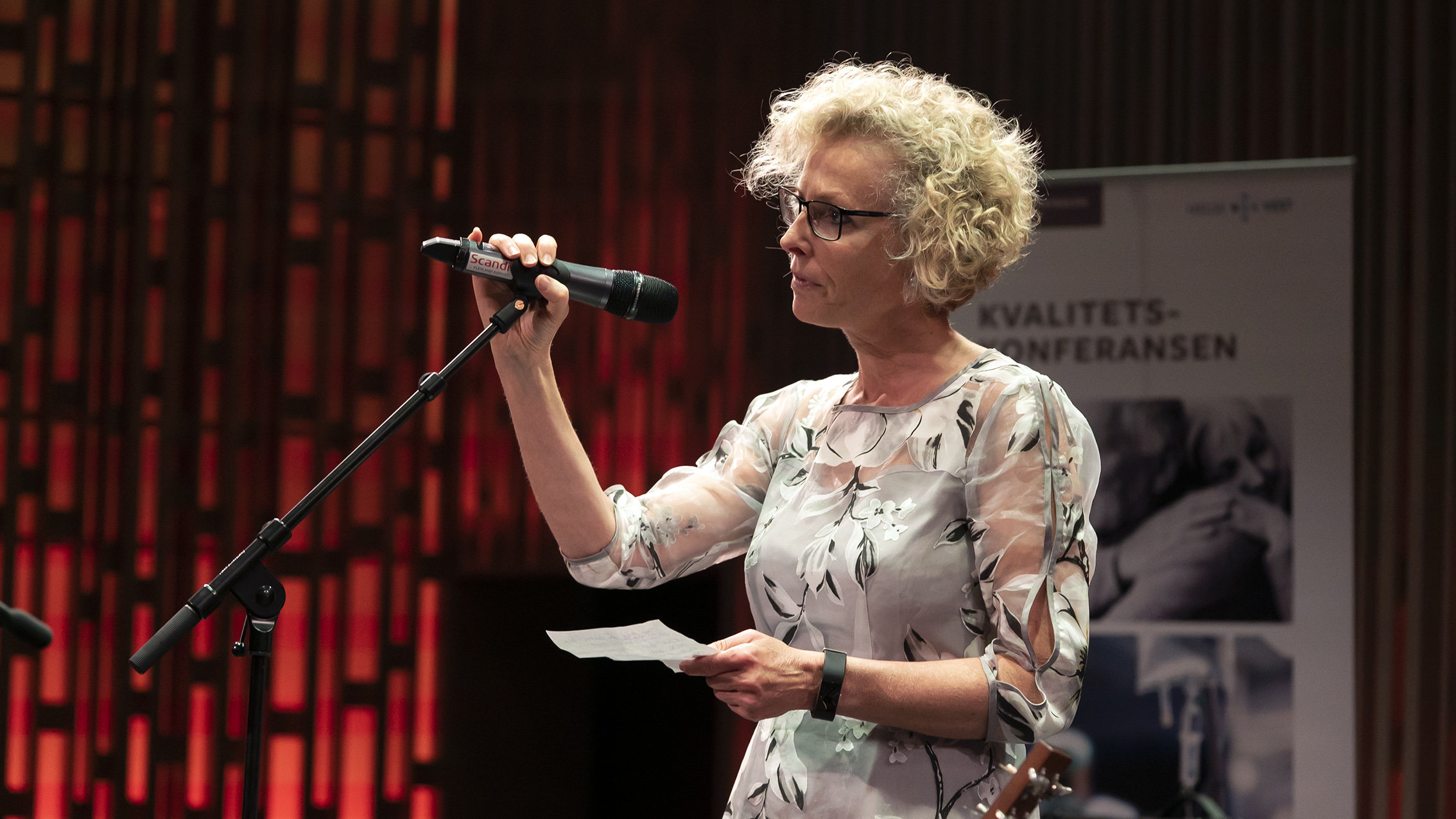 Prisvinnar Erna Harboe snakkar i mirkofon. Foto.